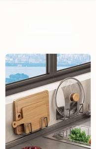 Detail of adjustable gun grey wall mount racks holding a lid and wooden cutting board