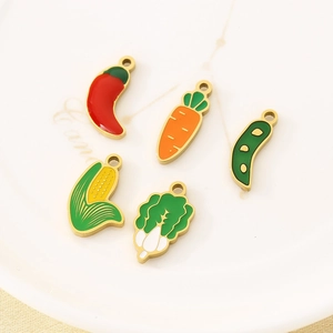Macro shot of colorful enamel vegetable charms in a white ceramic dish for DIY jewelry
