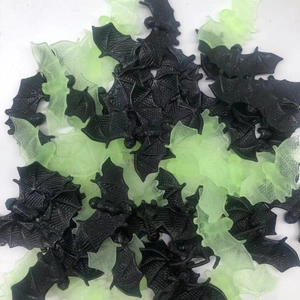 Detailed close-up of small plastic bats in black and glow-in-the-dark green for Halloween