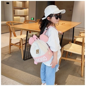 Detail showing pink and white color block kids backpack with cute round ears and text