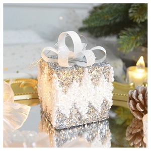 Close-up of sparkling silver Christmas gift box with 3D glitter bow and snowflake texture