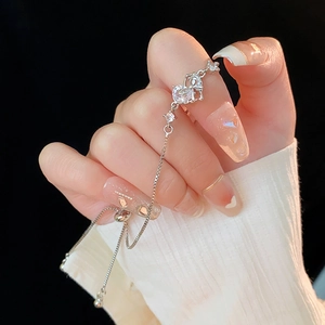 Close-up of silver zircon heart crown bracelet with adjustable drawstring on a hand