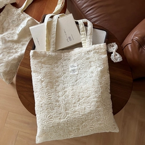 Macro view of beige lace embroidery texture and vintage tag on a cotton tote bag