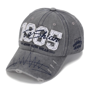 Detail of 1985 embroidery and navy zigzag stitching on grey washed cotton baseball cap