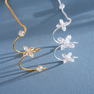 Dettaglio degli anelli a spirale a fiore in oro e argento con zirconi lucenti