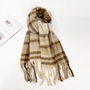 Close-up of brown and beige striped mohair scarf with long tassels on a white magazine background