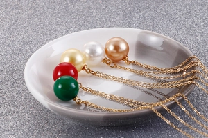 Gros plan de colliers avec pendentifs en perles de différentes couleurs sur un plat