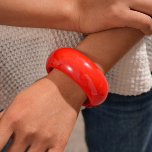 Close-up of bright red resin wide bangle on wrist with minimalist geometric style