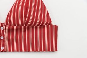 Detailed view of red and white vertical striped fabric with three white round buttons