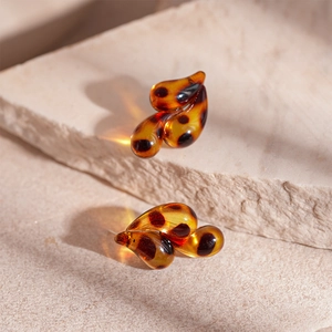 Macro shot of tortoiseshell resin leopard earrings on natural stone background