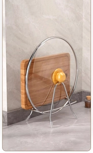 Close-up of stainless steel kitchen rack holding a wooden cutting board and glass lid
