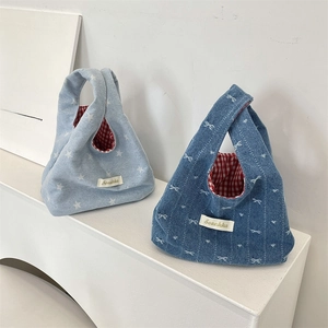 Detail of denim handbags with red checkered lining and star pattern
