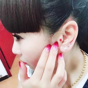 Close-up of a red crystal Shamballa ball stud earring on a model's ear lobe