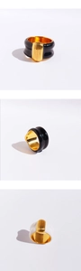 Macro detail of wide black and white enamel rings with vertical golden stripes