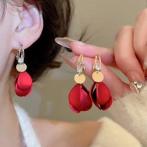 Detail view of red frosted petal tassel earrings with gold accents and sparkling crystals