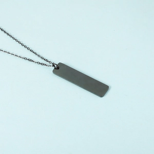 Macro view of minimalist black stainless steel rectangular bar pendant on a link chain