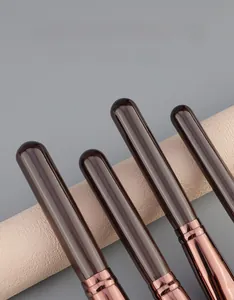 Detail of dark brown solid wood makeup brush handles with elegant rose gold metal ferrules