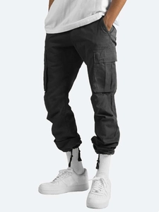 Detail view of charcoal grey cargo pants featuring functional large side flap pockets
