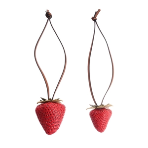 Realistic strawberry pendants on leather cords with green leaf detail on white background