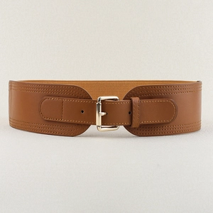 Detail of brown PU leather elastic waist belt with metal square pin buckle on beige fabric
