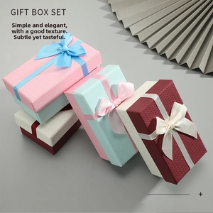 Macro detail of textured gift box surfaces with elegant wide ribbon bow decorations