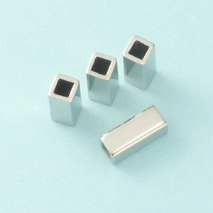 Macro view of four hollow titanium steel rectangular tubes with a polished silver finish