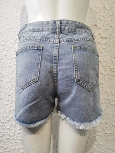 Détail du short en jean taille haute avec poches arrière et bordure effilochée tendance