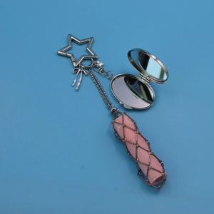 Close-up of metal mesh bag keychain with star clasp, mirror and pink lipstick holder