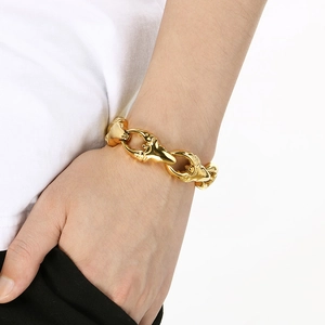 Close-up of gold-plated rock punk crab claw bracelet with chunky links on male wrist