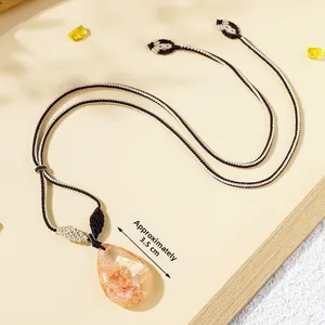 Detail of a 3.5cm natural yellow crystal water drop pendant with braided cord