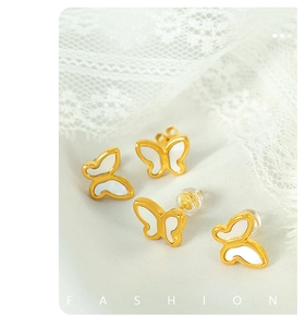 Macro shot of butterfly earrings with 18k gold plating and white mother-of-pearl inlay