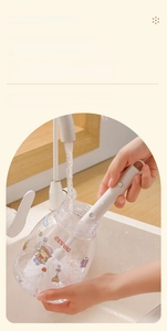 Close-up of long-handle bottle brush cleaning a transparent water bottle with dense bristles