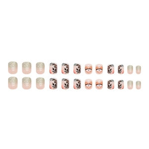Short round glitter press-on nails with black leaf silhouettes and hand-painted eye art