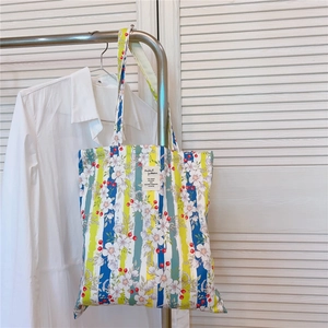 Détail d'un sac cabas en toile à fleurs avec étiquette tissée sur fond de porte