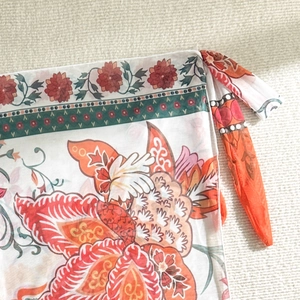 Close-up of semi-transparent floral print fabric and drawstring detail on beach sarong