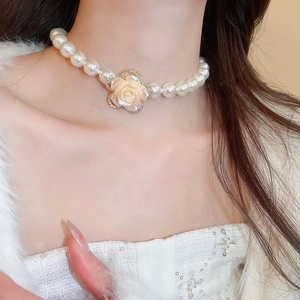 Detail of multi-layer pearl necklace with a diamond-encrusted floral centerpiece