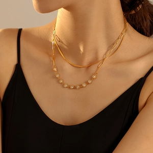 Double-layered golden necklace with heart zircon pendant on snake and oval link chains