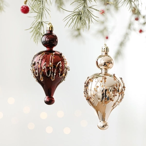 Elegant champagne and burgundy Christmas ornaments with beads hanging on a tree branch