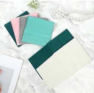 Flat lay of colorful microfiber jewelry pouches for rings and necklaces on marble surface