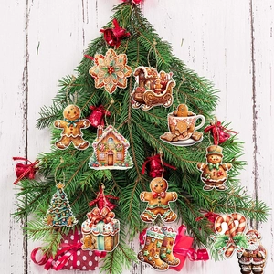 Gingerbread man and classic Christmas ornaments hanging on a festive green pine branch