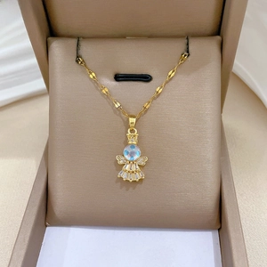 Macro shot of gold angel pendant featuring shimmering stones and crystal wings on jewelry box