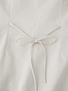 Detail of adjustable lace-up back tie on beige linen sleeveless top with neat stitching