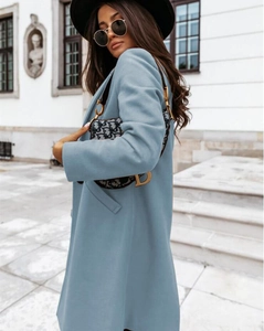 Detail of light blue wool coat with side view on elegant model in classic street style