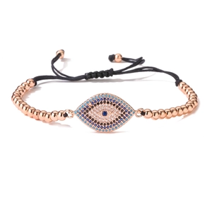 Detail of rose gold evil eye bracelet featuring blue cubic zirconia and black woven cord