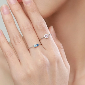 Anelli in argento sterling S925 con fiori rosa e pietre blu sulla mano