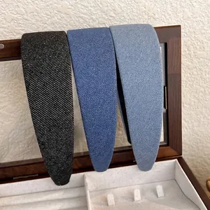 Trois serre-têtes rembourrés en denim noir et bleu sur un fond de boîte en bois