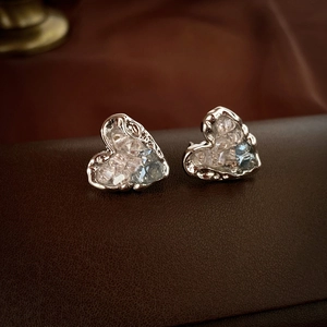 Détail de boucles d'oreilles cœur en argent avec cristaux bleus sur cuir foncé