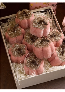 Close-up of pink velvet decorative pumpkins with gold glitter and sequins in a gift box