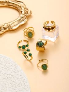 Detail of vintage gold-plated rings with turquoise and jasper stones on elegant props