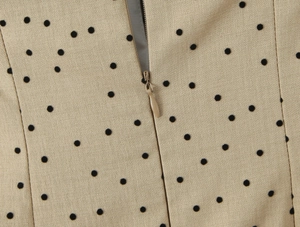 Detail of khaki dotted dress featuring a seamless invisible zipper and flocked texture